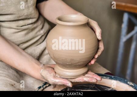 Potter holds just hired by pitcher. Ceramic skills. Sculptor sculpts products from white clay. Workshop pottery.Ukraine, national traditions Stock Photo