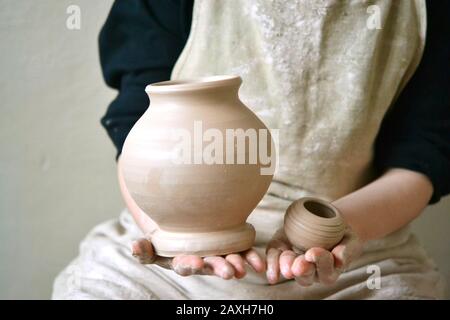 Potter holds just hired by pitcher. Ceramic skills. Sculptor sculpts products from white clay. Workshop pottery.Ukraine, national traditions Stock Photo