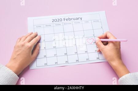 Female hands passing round with heart in Calendar on 14 Februar Stock Photo