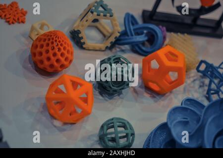 Models printed by 3d printer. Dark. Bright colorful objects printed on a 3d printer on a table. Modern additive technologies 4.0 industrial revolution Stock Photo