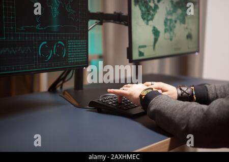 Close up of cyber criminal trying to break a firewall from his computer. Stock Photo