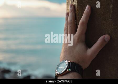 Person holding the stanchion with wrist watch. Time Concept. Stock Photo
