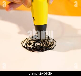 Man 3d pen drawing circles close-up on white paper Stock Photo