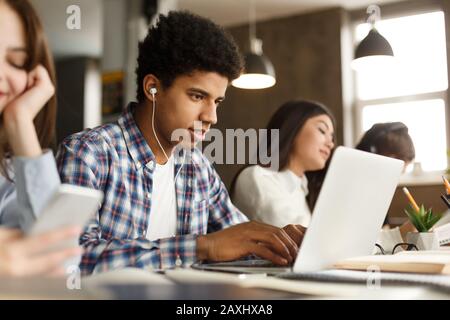Afro student doing homework in college library Stock Photo
