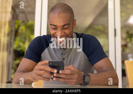 Young man smiling while using his mobile phone Stock Photo
