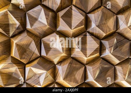 3D decorative wall with imitation wood texture for the interior of an unusual hexagonal geometric shape similar to honeycombs. Brown light background Stock Photo