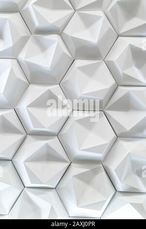 3D decorative wall for the interior of an unusual hexagonal geometric shape similar to honeycombs. White light background with a pattern imitating a t Stock Photo