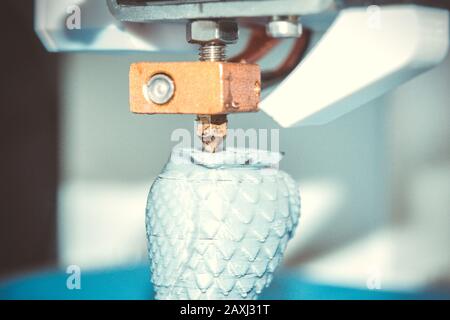 HD 1080 3D printer prints, creates, pouring, yellow a figure, shape of plastic, close-up. 3D printer prints red shapes on a red background Stock Photo
