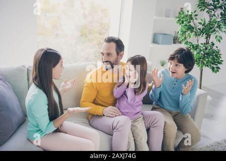 Top above high angle view photo of preteen girl sit couch tell school news her younger sister brother feel surprised scream wow omg dad daddy enjoy Stock Photo