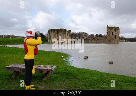 Flint, UK: Feb 11, 2020: An unusually high spring tide in the aftermath of storm Ciara sees the River Dee reach the walls of the castle. In the foregr Stock Photo