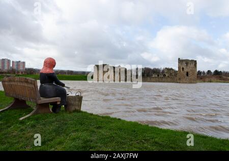 Flint, UK: Feb 11, 2020: An unusually high spring tide in the aftermath of storm Ciara sees the River Dee reach the walls of the castle. In the foregr Stock Photo