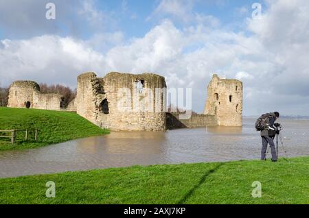 Flint, UK: Feb 11, 2020: An unusually high spring tide in the aftermath of storm Ciara sees the River Dee reach the walls of the castle. A photographe Stock Photo