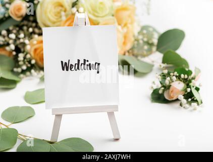 Small easel with text on creative background with roses Stock Photo