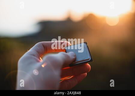 Person holding a computer processor in hand outside at sunset. Point of view shot. CPU Concept. Stock Photo