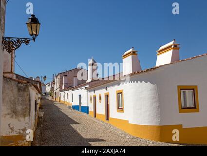 Traditional architecture with large chimneys in  whitewashed houses and street small rural settlement village of Terena, Alentejo Central, Portugal Stock Photo