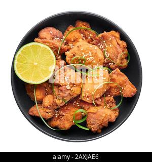 Chicken Karaage in black bowl isolated on white background. Karaage is traditional japanese cuisine dish with deep fried marinated chicken. Stock Photo