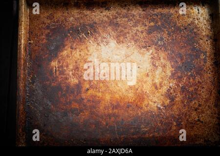 Old stained vintage empty metal tray background texture for oven baking or cooking in a close up view from overhead Stock Photo