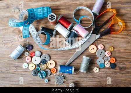 Top view of objects about Sewing equipment set on a wooden background. Sewing and tailoring concept Stock Photo