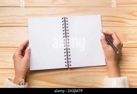 Woman holding pencil and spiral notepad as mockup for your design Stock Photo