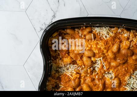 Plastic container with grated cheese on table Stock Photo - Alamy