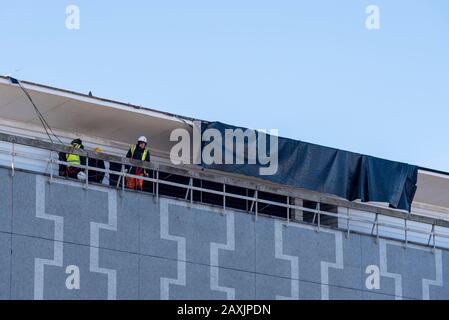 Southend on Sea, Essex, UK. 12th Feb, 2020. Local agencies are taking the chance as the wind drops to clear up after the destructive winds of storm Ciara. Roofing material which was blown off of the roof of the Cliffs Pavilion theatre has been cut away and allowed to drop to the ground Stock Photo