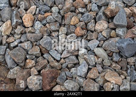Grey granite stones on natural northern seashore. Close up gray rocks texture, rough surface material. For design, web Stock Photo