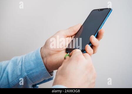 Hand connecting cable to mobile phone Stock Photo