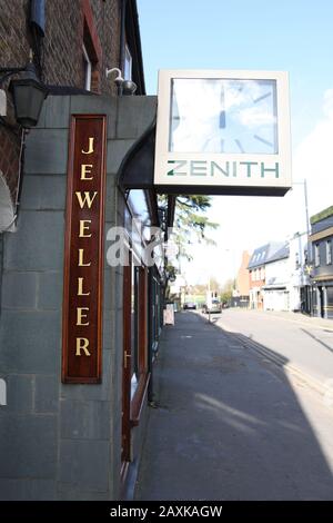 Wooden Jeweller signage with Zenith external clock on side of Newboulds Jewellers in Esher, Surrey, UK, looking down road Stock Photo