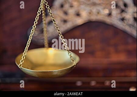 Close-up of an old gold scale with various decorations in a wooden box for storage. Stock Photo