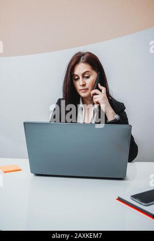 Female boss talking on the phone in the office Stock Photo