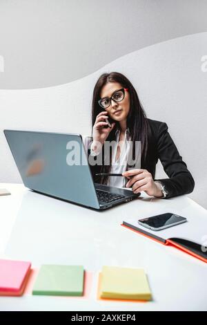 Female boss talking on the phone in the office Stock Photo