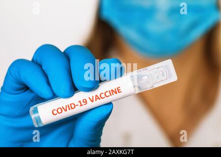 Doctor holds in his hand an ampoule with a vaccine against coronavirus COVID-19, close-up Stock Photo