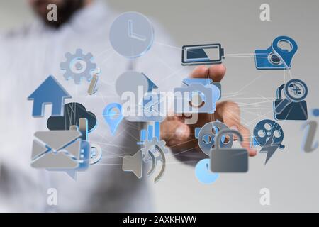 Businessman pressing a virtual projection of different icons connected with cloud Stock Photo