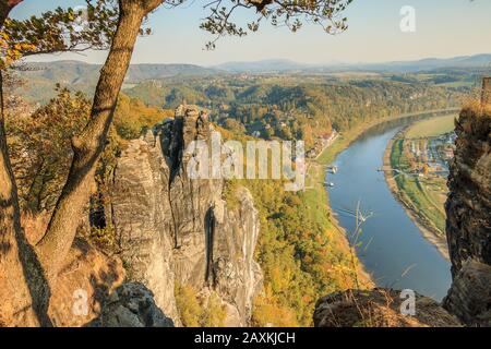 Elbe valley in Rathen. Autumn mood in the Saxon Switzerland National Park. Rock formation and trees in the evening sunshine overlooking the Elbe Stock Photo