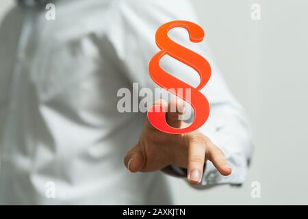 Person showing a virtual projection of a digital paragraph law symbol Stock Photo