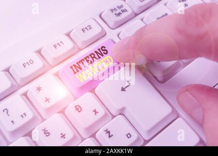 Writing note showing Interns Wanted. Business concept for temporary position with an emphasis on the job training Stock Photo