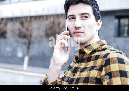 phone intimidation. close up portrait of a serious man with focused view speaking on the phone and looking away Stock Photo