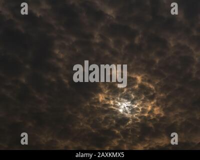 Amazing scientific background - solar eclipse in dark cloudy sky, mysterious natural phenomenon when Moon passes between planet Earth and Sun Stock Photo