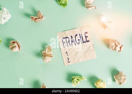 Handwriting text Fragile. Conceptual photo Breakable Handle with Care Bubble Wrap Glass Hazardous Goods Colored crumpled rectangle shaped reminder pap Stock Photo