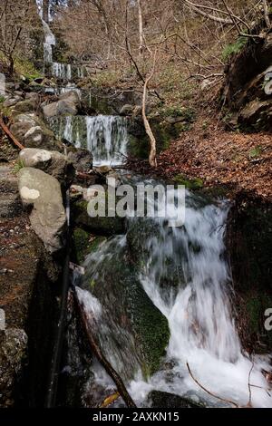 Vertical shot of a small waterfalls with a series of cascades from a mountain spring in Tokyo, Japan Stock Photo