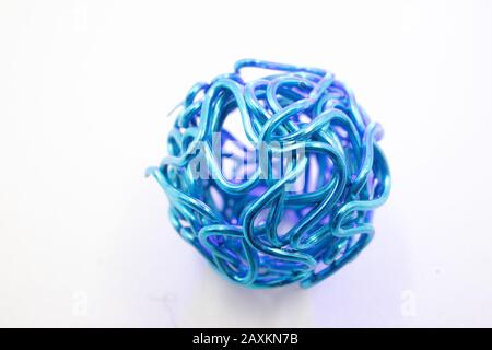 A closeup shot of a teal colored metal wire ball against a white background Stock Photo