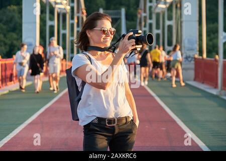 Mature woman photographing with camera, photo journalist, travel blogger Stock Photo