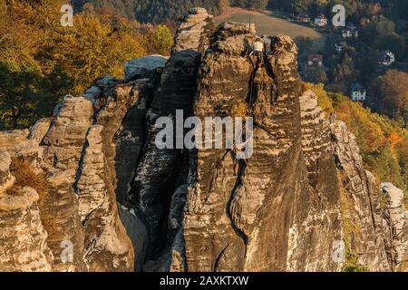 Climbing in the Saxon Switzerland National Park. Elbe Sandstone Mountains in autumn with trees and forests. Autumn mood from viewpoint Bastei Bridge Stock Photo