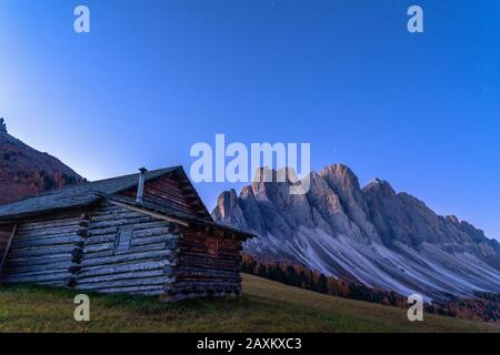 Autumn sunrise over the Odle Group seen from wood hut at Gampen Alm, Funes Valley, Dolomites, Bolzano, South Tyrol, Italy Stock Photo