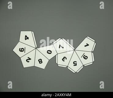 Geometric shape cut out of paper and photographed from above on grey background. Geometry net of Decahedron 2-dimensional shape that can be folded to Stock Photo