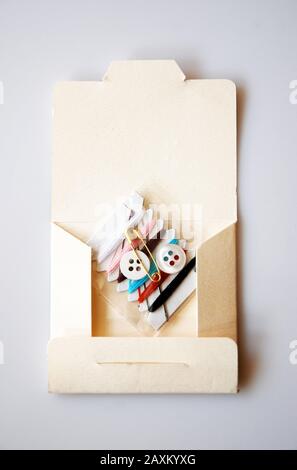Sewing kit cardboard with buttons on grey background vertical Stock Photo