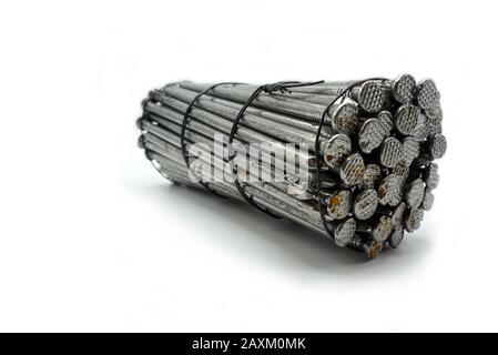Steel construction nails of different lengths tied together in groups. Common nails and spikes on white background. New and rusty nails and spikes det Stock Photo