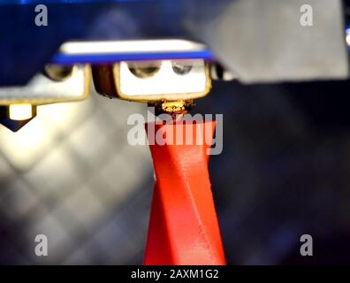 Modern 3D printer printing figure close-up macro. Automatic three dimensional 3d printer performs plastic pink and blue colors modeling in laboratory. Stock Photo