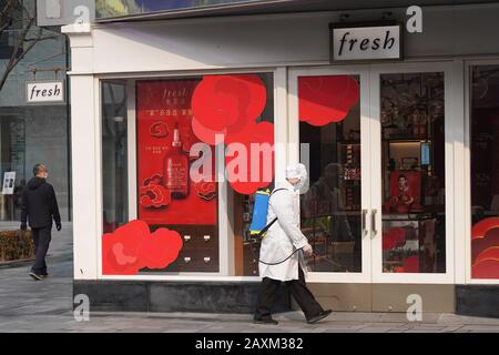 Beijing, China. 12th Feb, 2020. A staff member disinfects the environment at a street in Sanlitun business area in Beijing, capital of China, on Feb. 12, 2020. Work and production has resumed gradually in enterprises, communities and malls, etc. in Beijing since Feb. 10 with comprehensive measures taken to prevent and control the epidemic caused by the novel coronavirus. Credit: Ju Huanzong/Xinhua/Alamy Live News Stock Photo