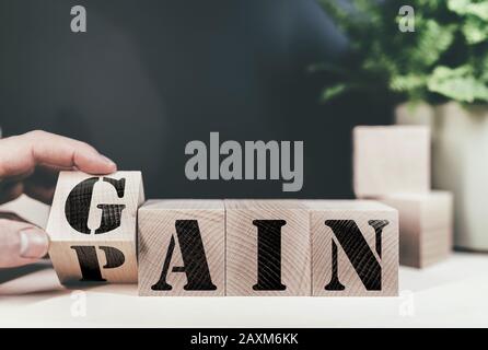 changing word PAIN to GAIN on wooden blocks, no pain no gain success concept Stock Photo